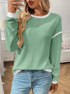 Detail shot of mint green knit sweater with white contrast piping on collar and cuffs