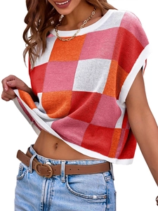 Dettaglio del crop top in maglia a scacchi rossi e arancioni con scollo a coste bianche