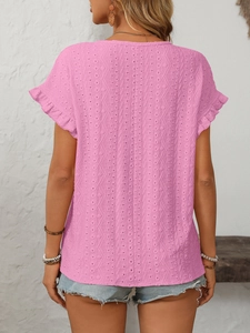 Détail du haut rose ajouré avec texture florale délicate et volants sur les manches