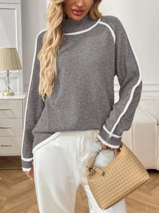 Détail d'un pull en tricot à col montant avec rayures contrastées et coupe décontractée