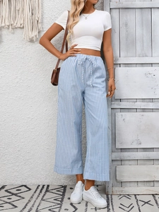 Dettaglio dei pantaloni a gamba larga a righe bianche e blu con vita alta a coulisse
