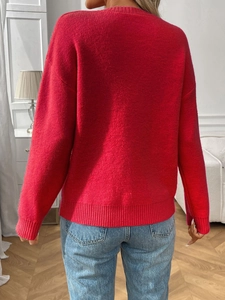 Detail of red jacquard sweater with bow pattern and comfortable ribbed cuffs