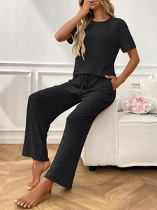 Detail of ribbed knit fabric texture on black loungewear set with drawstring waist