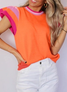 Detailopname van de oranje gebreide top met contrasterende roze en paarse streepdetails
