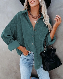 Detail of dark green oversized corduroy shirt with textured fabric and chest pocket