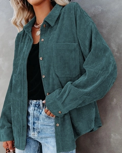 Detailed close-up of teal corduroy fabric texture on a loose-fit long-sleeve casual shirt