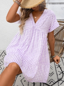 Detail of V-neckline and purple plaid pattern on loose summer vacation dress