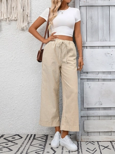 Dettaglio dei pantaloni a gamba larga a righe kaki a vita alta con coulisse in vita