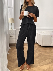 Detail of black ribbed knit pajamas set showing soft fabric texture and waist drawstring