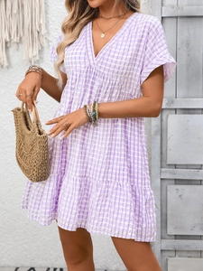 Detailed view of the V-neck and purple checkered fabric pattern on a breezy summer dress