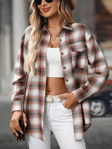 Detail of plaid shacket featuring chest pockets and classic tortoise buttons