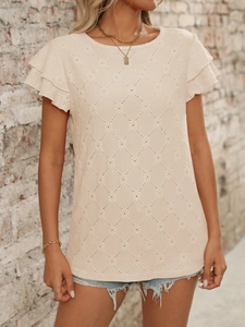 Detail of apricot short-sleeved top showing textured diamond hollow pattern and ruffled sleeves