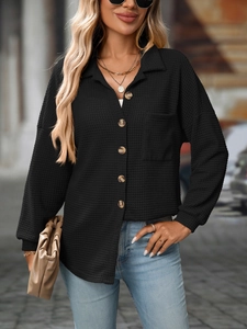 Detail of waffle knit fabric and wood-style buttons on a casual black long sleeve shirt
