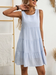 Detail of light blue gingham sleeveless dress with tiered skirt in minimalist interior