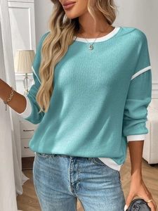 Close-up of turquoise knit sweater with white contrast piping and ribbed texture detail