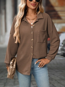 Close-up of brown waffle knit texture and buttoned pocket detail on women's casual shirt