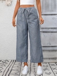 Dettaglio dei pantaloni a righe a vita alta con coulisse in vita e gamba larga