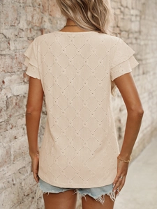 Detail of hollow diamond crochet knit pattern and ruffled sleeves on beige top