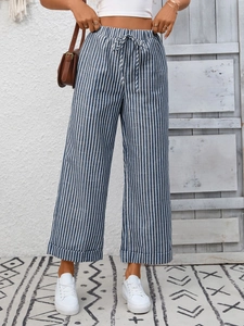 Dettaglio della trama dei pantaloni a righe bianche e blu a vita alta con coulisse in vita