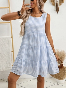 Detail of blue and white plaid sleeveless dress showing tiered ruffle hem and cotton fabric