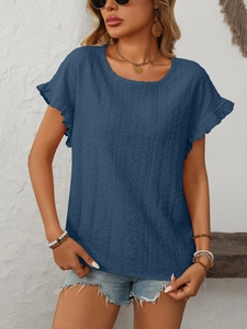 Détail du haut bleu marine à broderie ajourée et manches à bords festonnés élégants