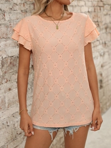 Detail of peach hollow-out knit fabric showing diamond patterns and layered ruffle sleeves
