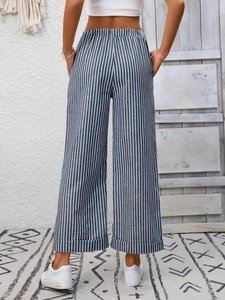 Dettaglio dei pantaloni a gamba larga a righe con vita alta elastica e risvolto sull'orlo