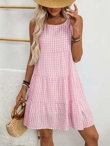 Detail view of tiered gingham summer dress with flowy layers and pink checkered pattern