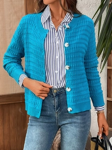 Detail of sky blue knit cardigan featuring textured check pattern and white buttons