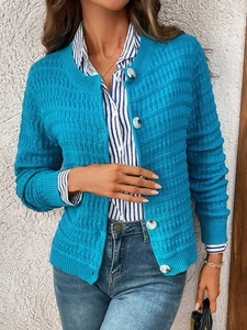 Detail of bright blue knit cardigan with waffle texture and pearlescent buttons