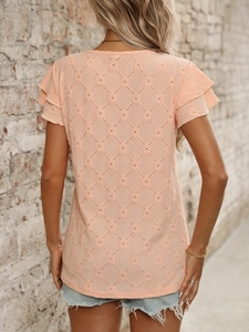 Detail of apricot hollow jacquard fabric and stylish ruffle sleeves on a summer top