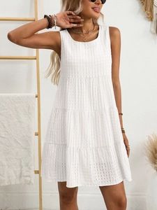 Detail of white sleeveless dress showing layered tiered skirt and plaid textured fabric