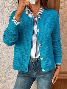 Detail of teal knit cardigan featuring textured checker pattern and pearlescent buttons