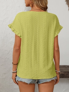 Détail du haut vert à manches courtes avec broderie anglaise et poignets volantés
