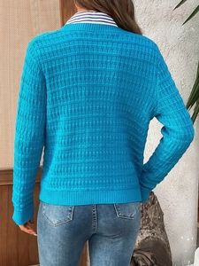 Close-up back view of bright blue knit cardigan featuring a textured checkerboard pattern