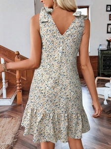 Détail de robe d'été fleurie avec dos en V et nœuds papillons réglables aux épaules