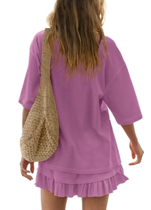 Rear view of purple oversized t-shirt and ruffled skirt set with straw bag accessory