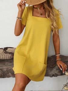 Detail view of ginger yellow square neck dress with functional front patch pockets