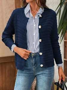 Close-up of dark blue knit cardigan showing fine texture and large contrast buttons