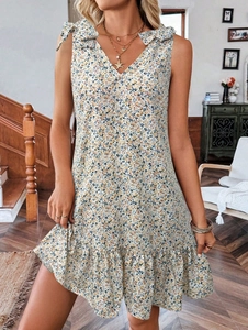 Détail de la robe à fleurs avec col en V, nœuds aux épaules et ourlet à volants élégant