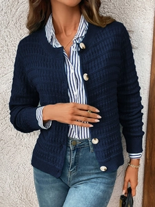 Detail view of navy blue knit cardigan featuring decorative large gold metal buttons