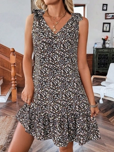 Détail de robe fleurie sans manches col en V avec nœuds d'épaule et ourlet volanté