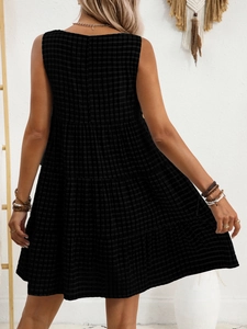 Back view of a sleeveless black checkered tiered dress with casual summer styling
