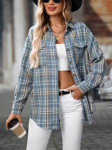Detail of blue and white plaid shirt featuring classic collar and two flap chest pockets