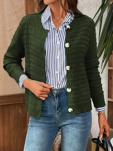 Detail view of dark green waffle knit cardigan with large white buttons for autumn