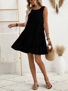 Detail of a tiered black gingham sleeveless dress styled for a bohemian summer look