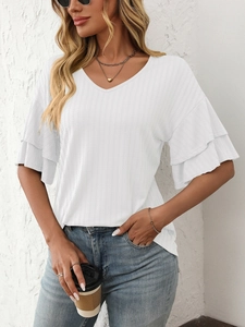 Close-up of white V-neck top featuring double layered ruffle sleeves and textured fabric