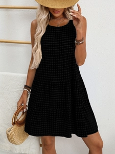 Close-up of black and white gingham sleeveless tiered dress with textured fabric