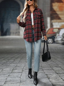 Detail of red and black plaid flannel shirt with dual chest pockets and buttoned cuffs