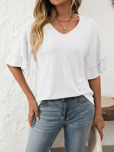 Close-up of elegant V-neck and layered ruffle sleeve details on white textured fabric